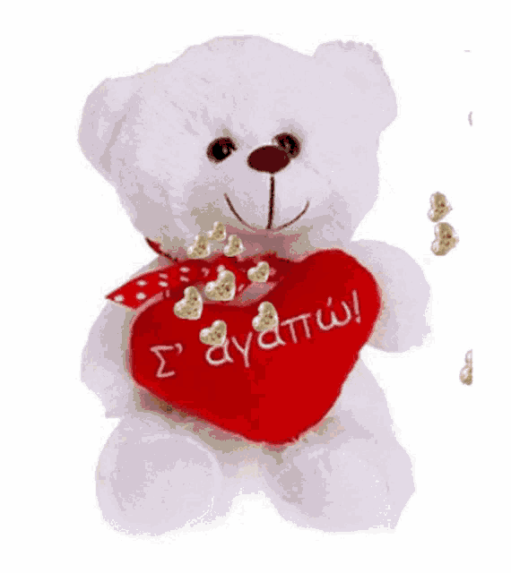 a white teddy bear is holding a red heart with the word ayottio written on it .
