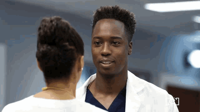 a man in a lab coat is looking at a woman