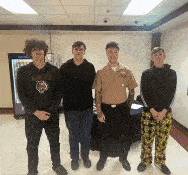 a man in a military uniform is standing next to a group of young men