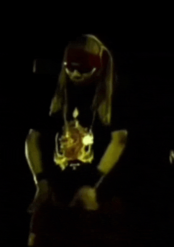a man with long hair and sunglasses is wearing a black shirt with a skeleton on it
