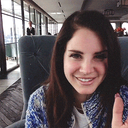 a woman in a blue and white sweater is smiling