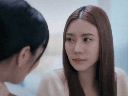 a woman with long hair looks at another woman
