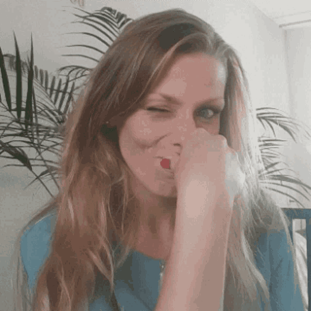 a woman with red nail polish covering her nose