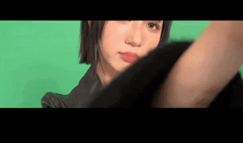 a close up of a woman 's face against a green background .