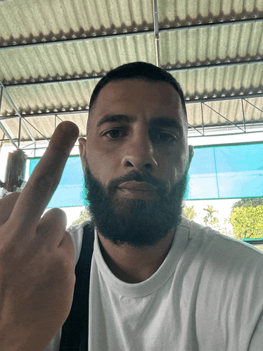 a man with a beard is giving a middle finger