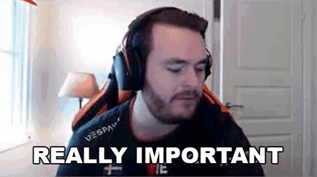 a man wearing headphones is sitting in a chair in front of a window and says `` really important '' .