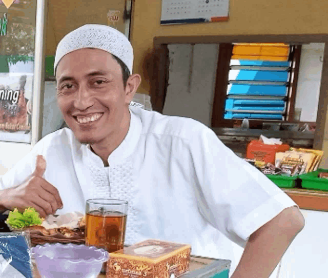 a man giving a thumbs up in front of a sign that says ' dining '