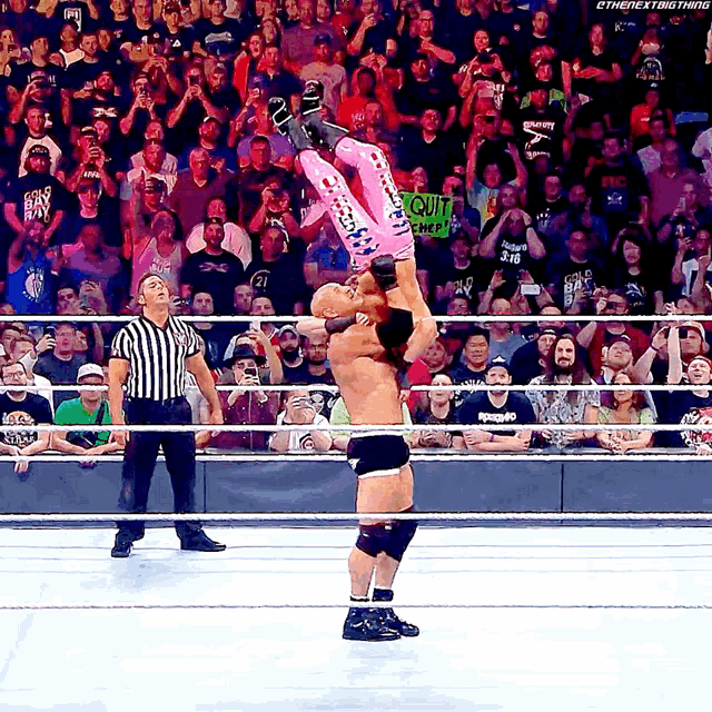 a wrestling match with a sign that says " quit " on it