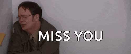 a man in a suit and tie is sitting in a corner with his arms outstretched and the words `` miss you '' .