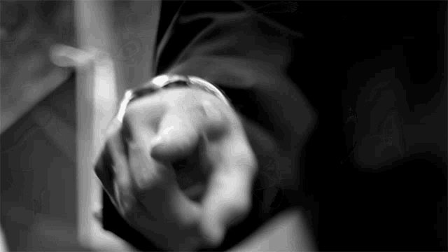 a black and white photo of a person 's hand holding a watch
