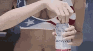 a woman in a bikini is opening a can of budweiser beer .