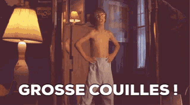 a shirtless boy is standing in a room with his hands on his hips and the words grosse couilles written above him