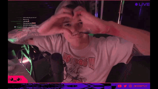 a man wearing a hot dog shirt is making a heart with his hands