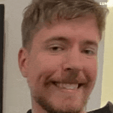 a man with a beard is smiling at the camera .