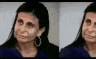 a woman is making a funny face while wearing a blue shirt and earrings .