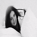 a black and white photo of a woman laying on a bed with a man .