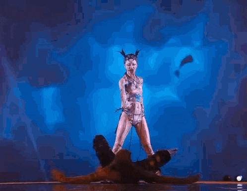 a group of people are standing on top of each other in a circle on a stage .
