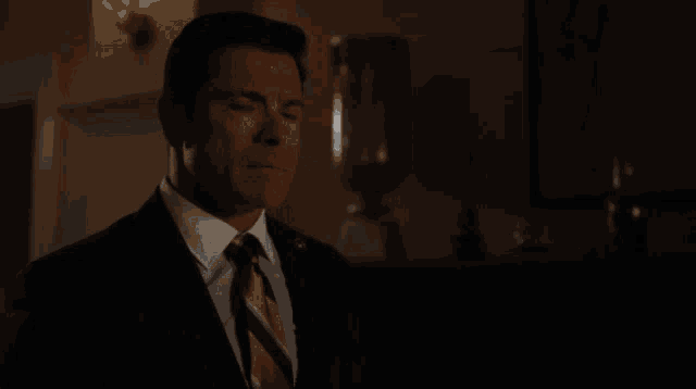 a man in a suit and tie is talking about water under the bridge