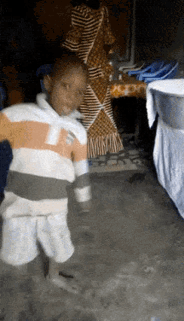 a young boy wearing a striped shirt with the letter p on the front