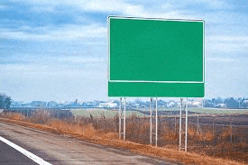 a green highway sign is sitting on the side of a road .