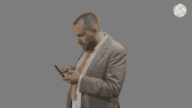 a man in a suit and tie looking at his phone