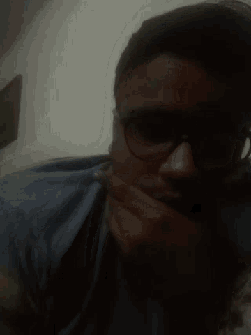a blurry picture of a man wearing sunglasses and a blue shirt