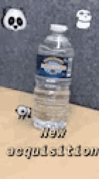 a bottle of water is sitting on a wooden table