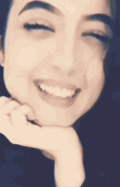 a close up of a woman 's face smiling with her eyes closed