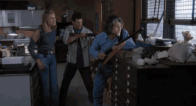 a man holding a gun in a room with two other men