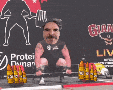 a man is lifting a barbell in front of a sign that says glam