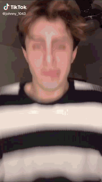 a man in a black and white striped shirt has a tiktok account named johnny_1013