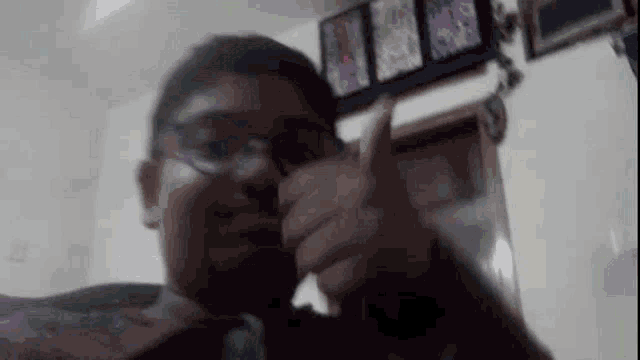 a man wearing glasses is taking a picture of himself in a living room .