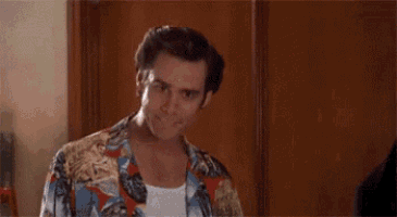a man in a colorful shirt is standing in front of a wooden door and says `` alright then ! ''