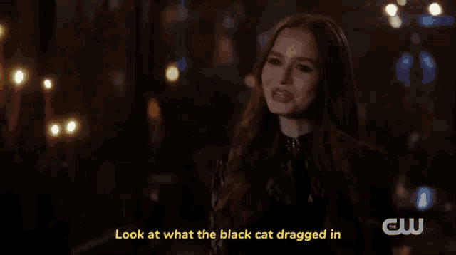 a woman in a black dress is talking to a man in a black shirt .