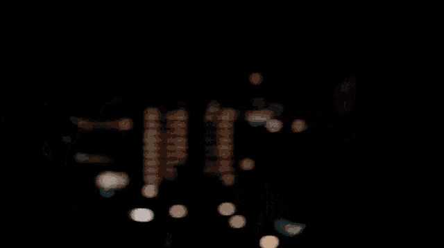 a close up of a man 's face in the dark with a beard and a black jacket .