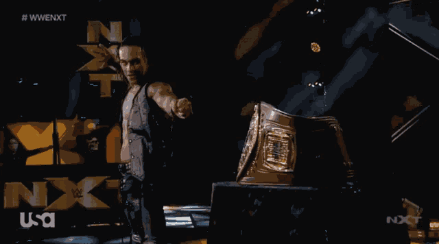 a man is standing in front of a sign that says nxt