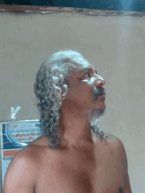 a man without a shirt stands in front of a cbs advertisement