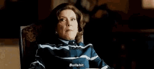 a woman is sitting in a chair and talking to someone and saying `` bullshit '' .