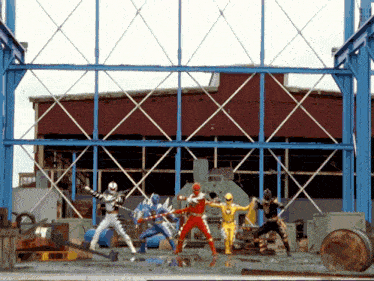 a group of power rangers are standing in front of a blue metal structure
