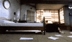 a bedroom with a bed and papers on the floor and a clock on the wall