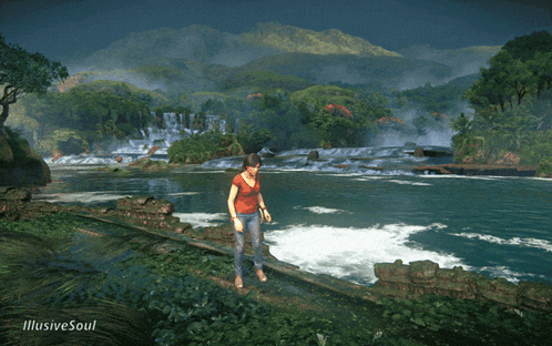 a woman in a red shirt is walking along a river with a waterfall in the background
