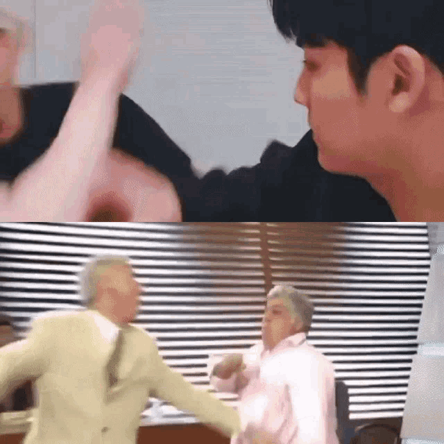 a man in a suit and a woman in a pink shirt are fighting in front of a window .