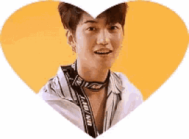 a young man is standing in a heart shaped frame and smiling .