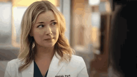 a woman in a lab coat with the name nastain park on the front