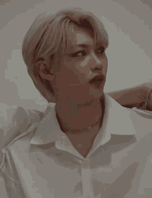 a close up of a person wearing a white shirt and necklace .