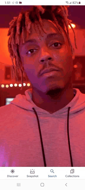 a close up of a man 's face on a phone screen with a search button at the bottom