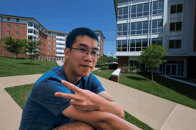 a man sitting in front of a building that says lee malpin