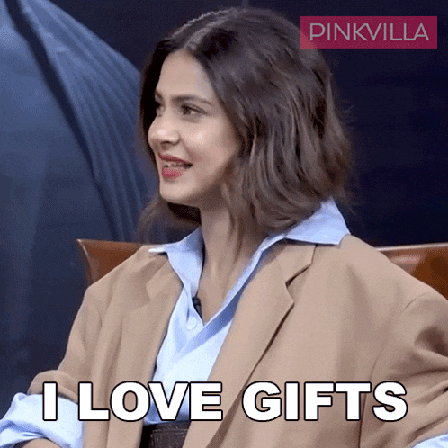 a woman sitting in a chair with the words " i love gifts " on the screen