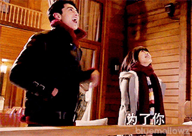 a man and a woman are standing in front of a wooden wall with the words bluemallowz on the bottom