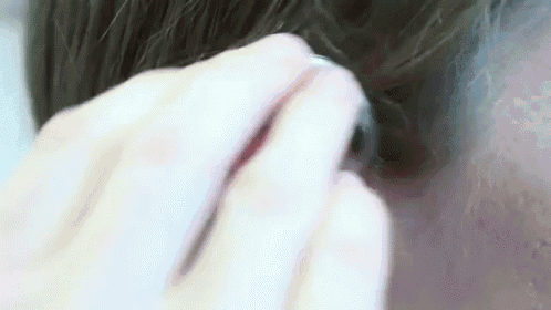 a close up of a person 's hair being brushed by a person 's hand .